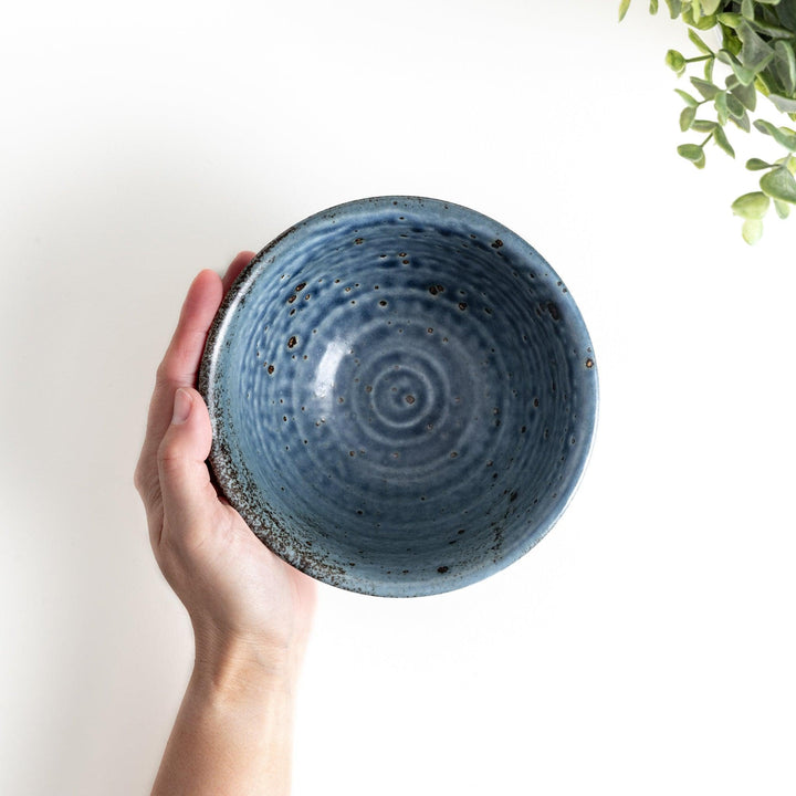 A navy ceramic rice bowl with a natural, rustic texture and a ribbed design.