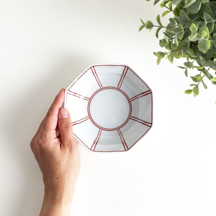 Small, white octagonal dessert bowls with thin blue and red lines forming geometric patterns.