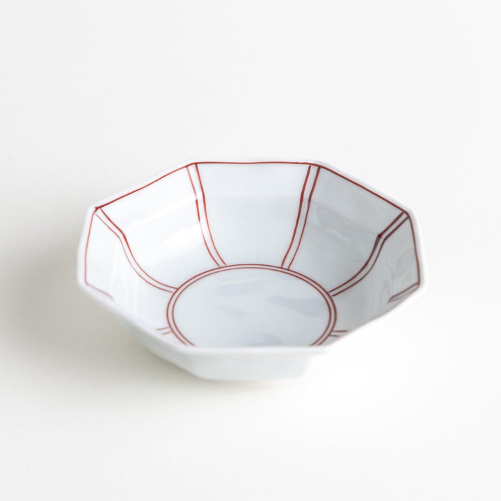 Small, white octagonal dessert bowls with thin blue and red lines forming geometric patterns.