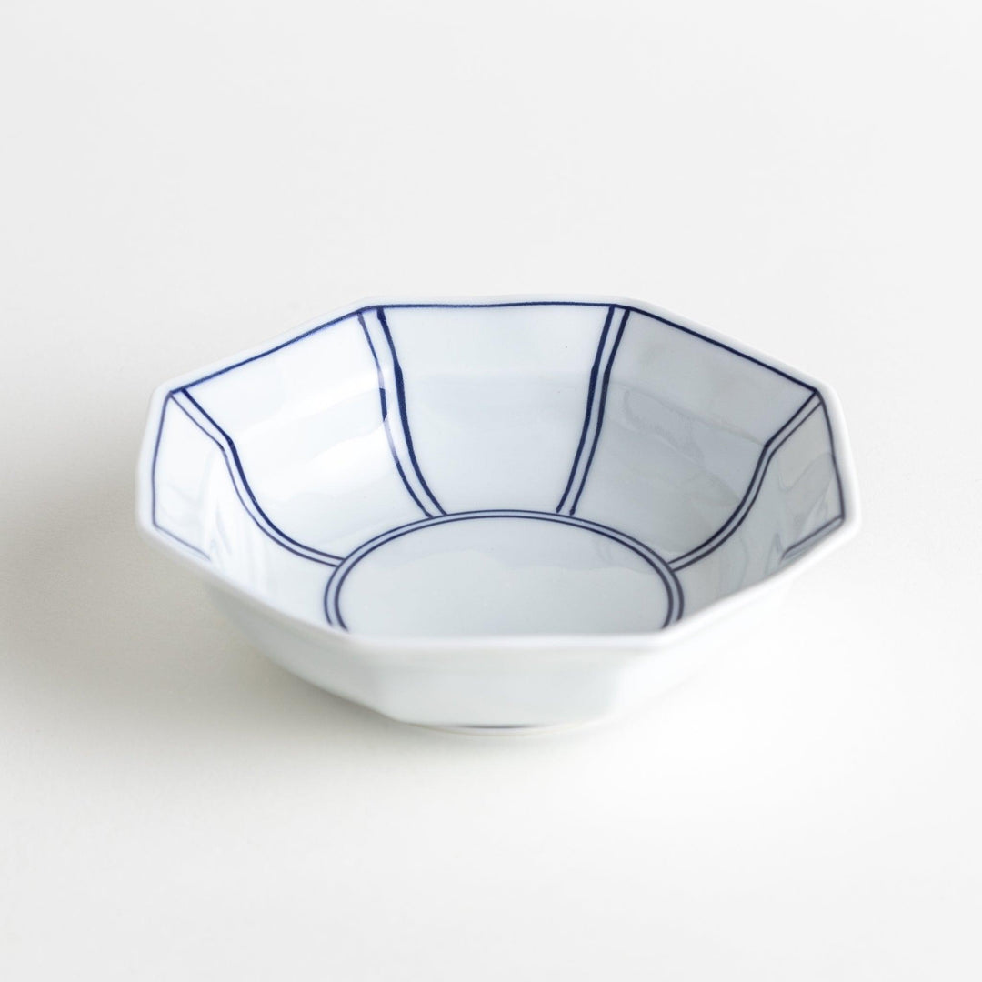 Small, white octagonal dessert bowls with thin blue and red lines forming geometric patterns.