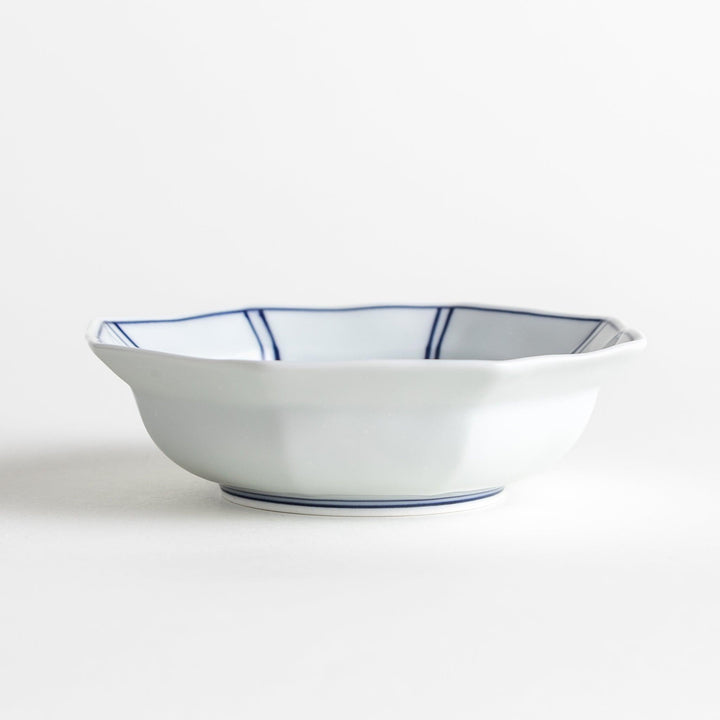 Small, white octagonal dessert bowls with thin blue and red lines forming geometric patterns.