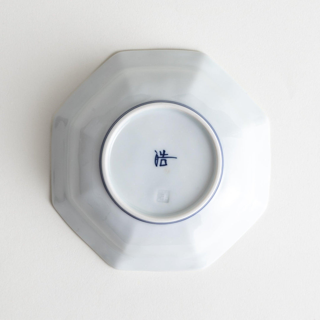 Small, white octagonal dessert bowls with thin blue and red lines forming geometric patterns.