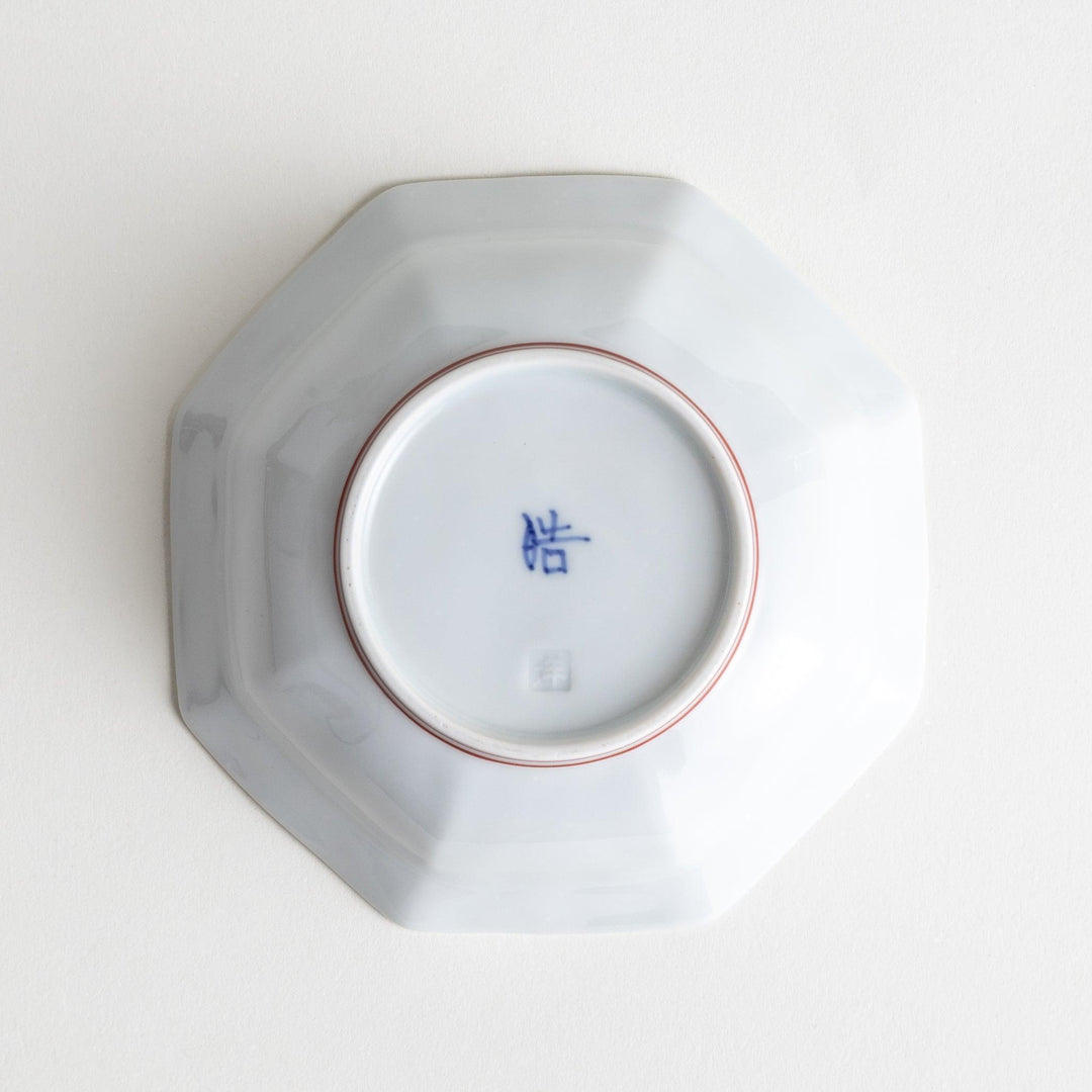 Small, white octagonal dessert bowls with thin blue and red lines forming geometric patterns.