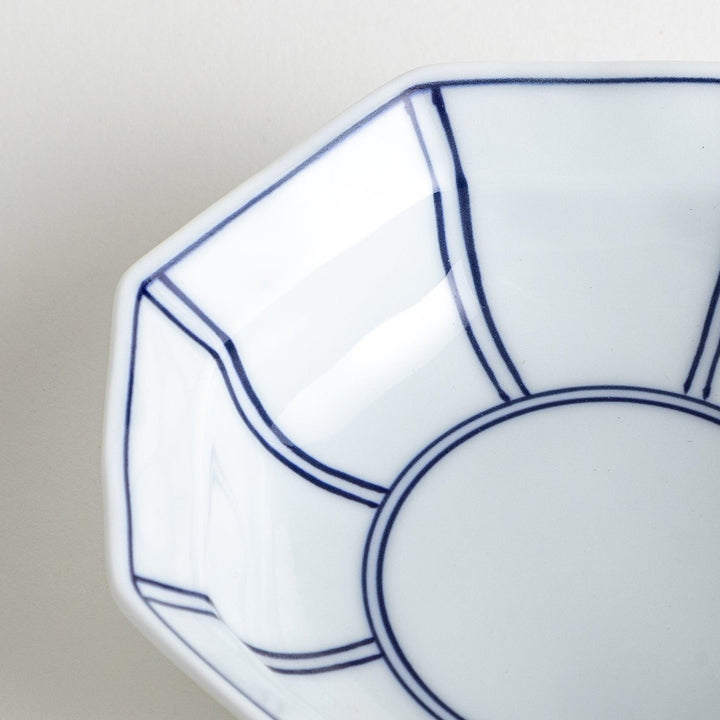 Small, white octagonal dessert bowls with thin blue and red lines forming geometric patterns.