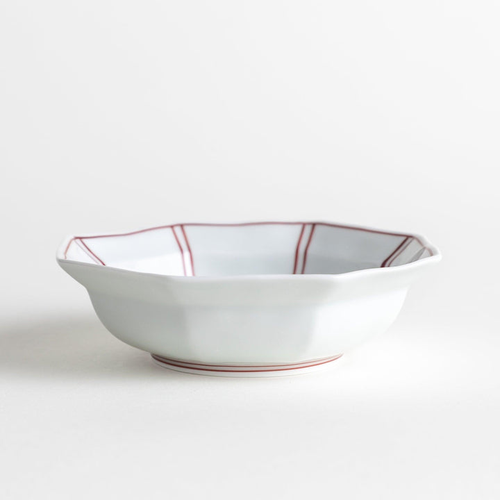 Small, white octagonal dessert bowls with thin blue and red lines forming geometric patterns.