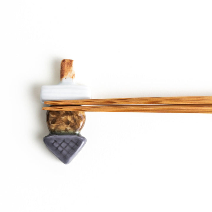 A ceramic chopstick rest designed to look like Japanese oden.