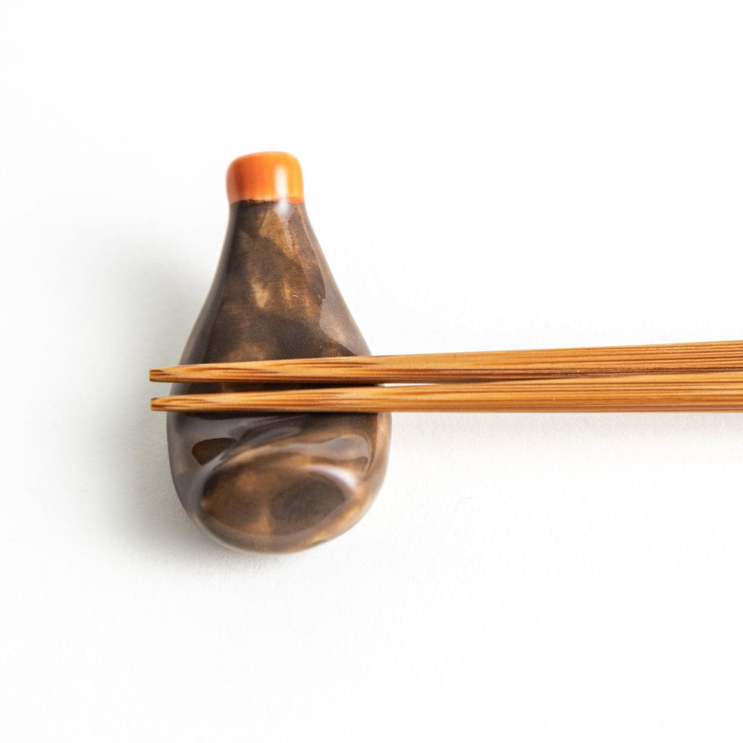 A ceramic chopstick rest resembling a okonomiyaki sauce bottle.