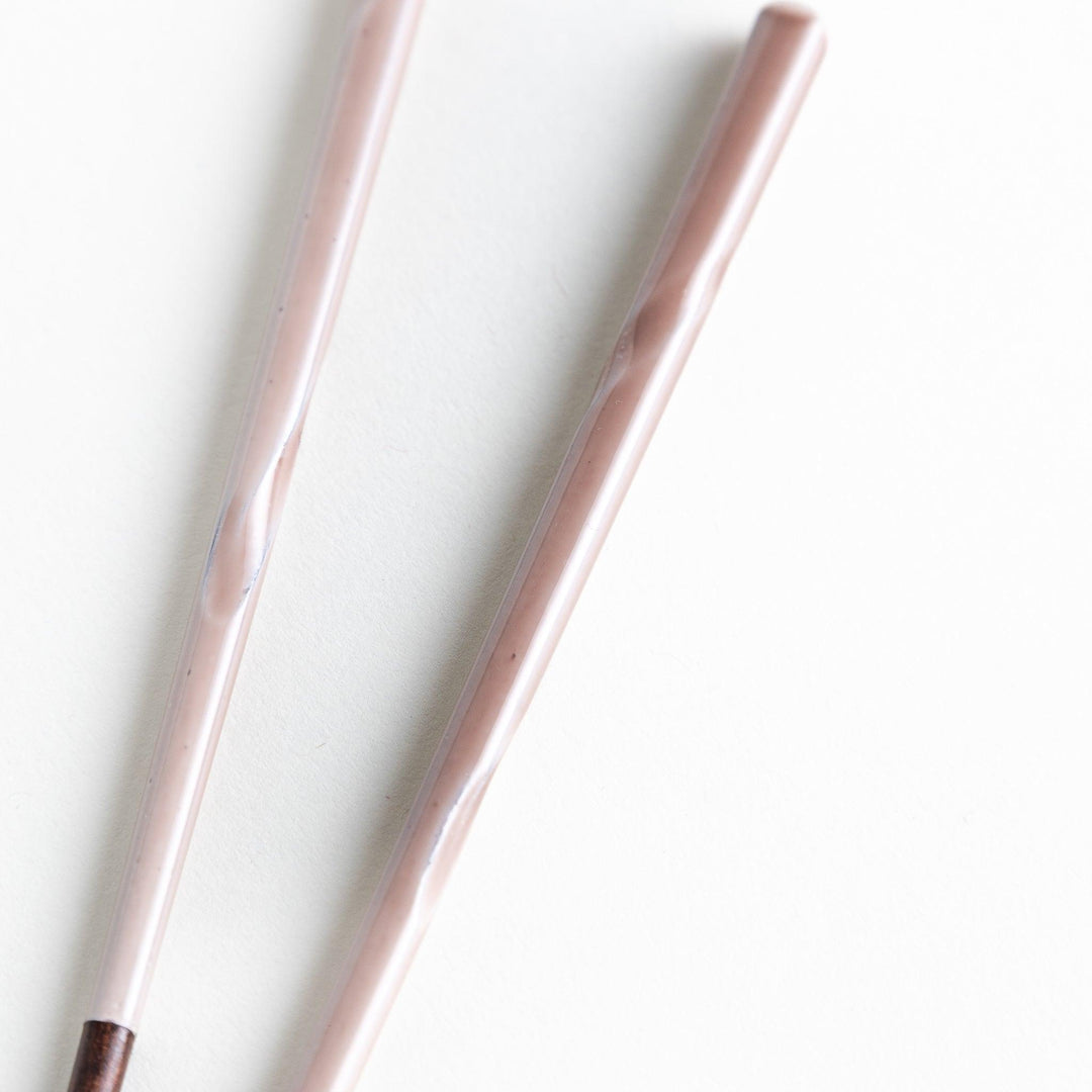 A set of chopsticks with twisted colored tops in soft pastel shades of pink, yellow, green, blue, and gray.