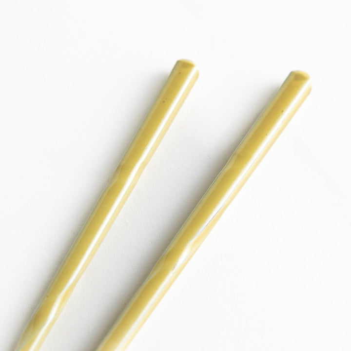 A set of chopsticks with twisted colored tops in soft pastel shades of pink, yellow, green, blue, and gray.