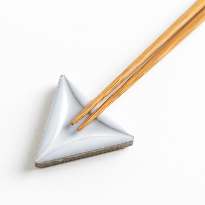 Five small, triangular ceramic chopstick rests in pastel colors—green, brown, blue, turquoise, and gray, arranged randomly on a white background.