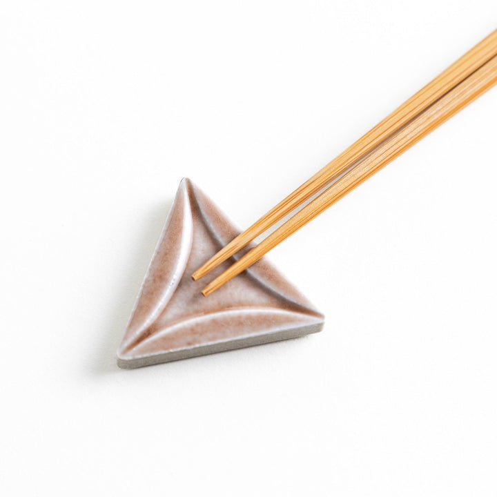 Five small, triangular ceramic chopstick rests in pastel colors—green, brown, blue, turquoise, and gray, arranged randomly on a white background.