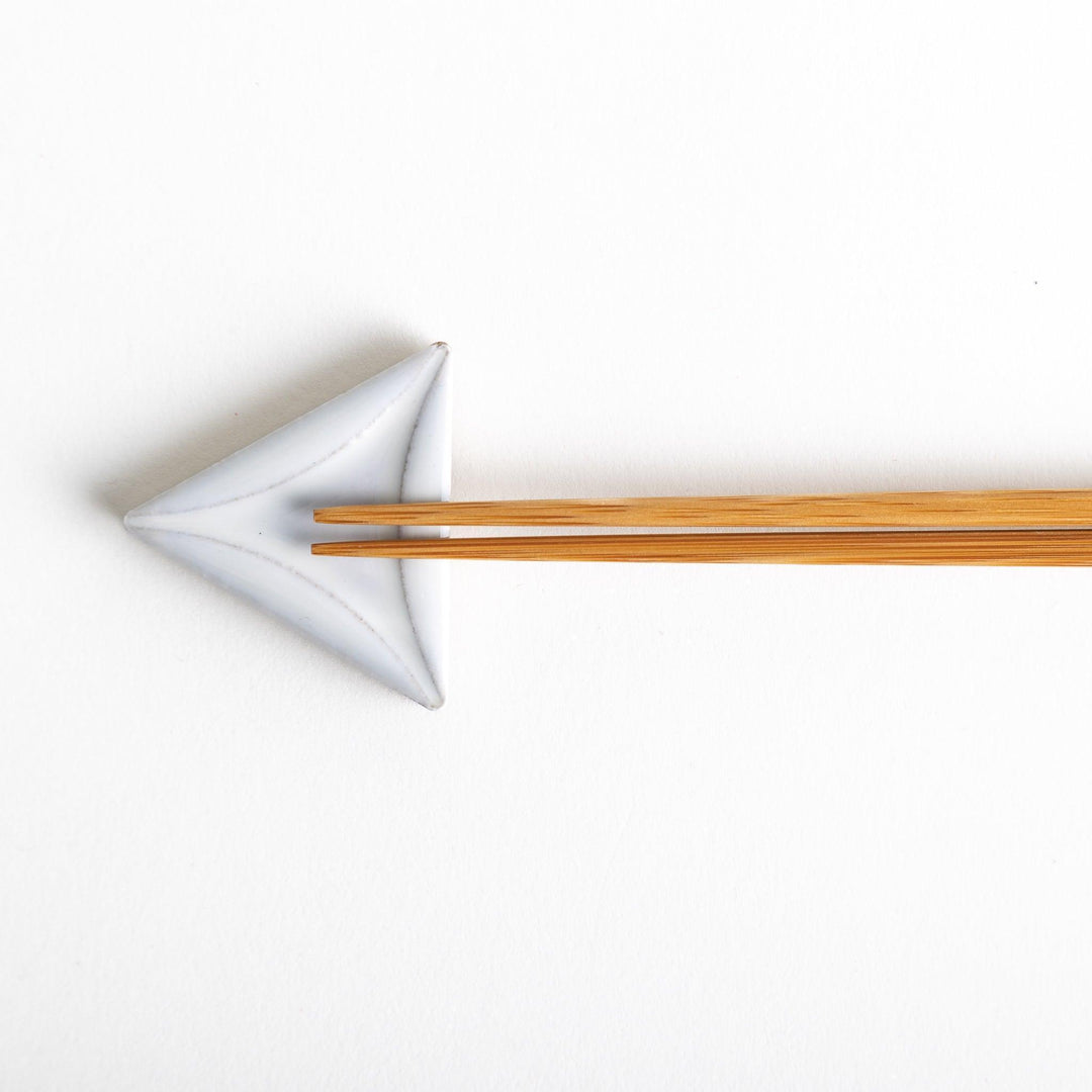 Five small, triangular ceramic chopstick rests in pastel colors—green, brown, blue, turquoise, and gray, arranged randomly on a white background.