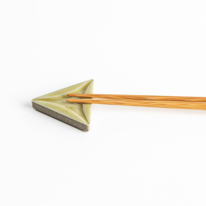 Five small, triangular ceramic chopstick rests in pastel colors—green, brown, blue, turquoise, and gray, arranged randomly on a white background.