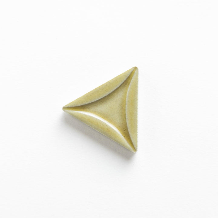 Five small, triangular ceramic chopstick rests in pastel colors—green, brown, blue, turquoise, and gray, arranged randomly on a white background.