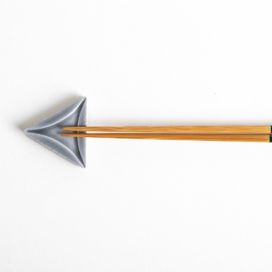 Five small, triangular ceramic chopstick rests in pastel colors—green, brown, blue, turquoise, and gray, arranged randomly on a white background.