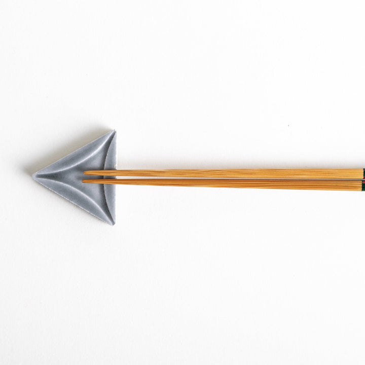 Five small, triangular ceramic chopstick rests in pastel colors—green, brown, blue, turquoise, and gray, arranged randomly on a white background.