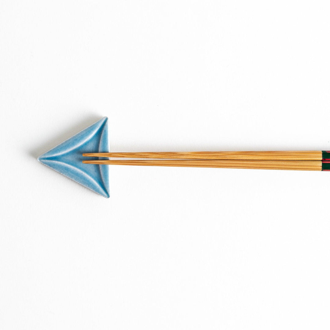 Five small, triangular ceramic chopstick rests in pastel colors—green, brown, blue, turquoise, and gray, arranged randomly on a white background.