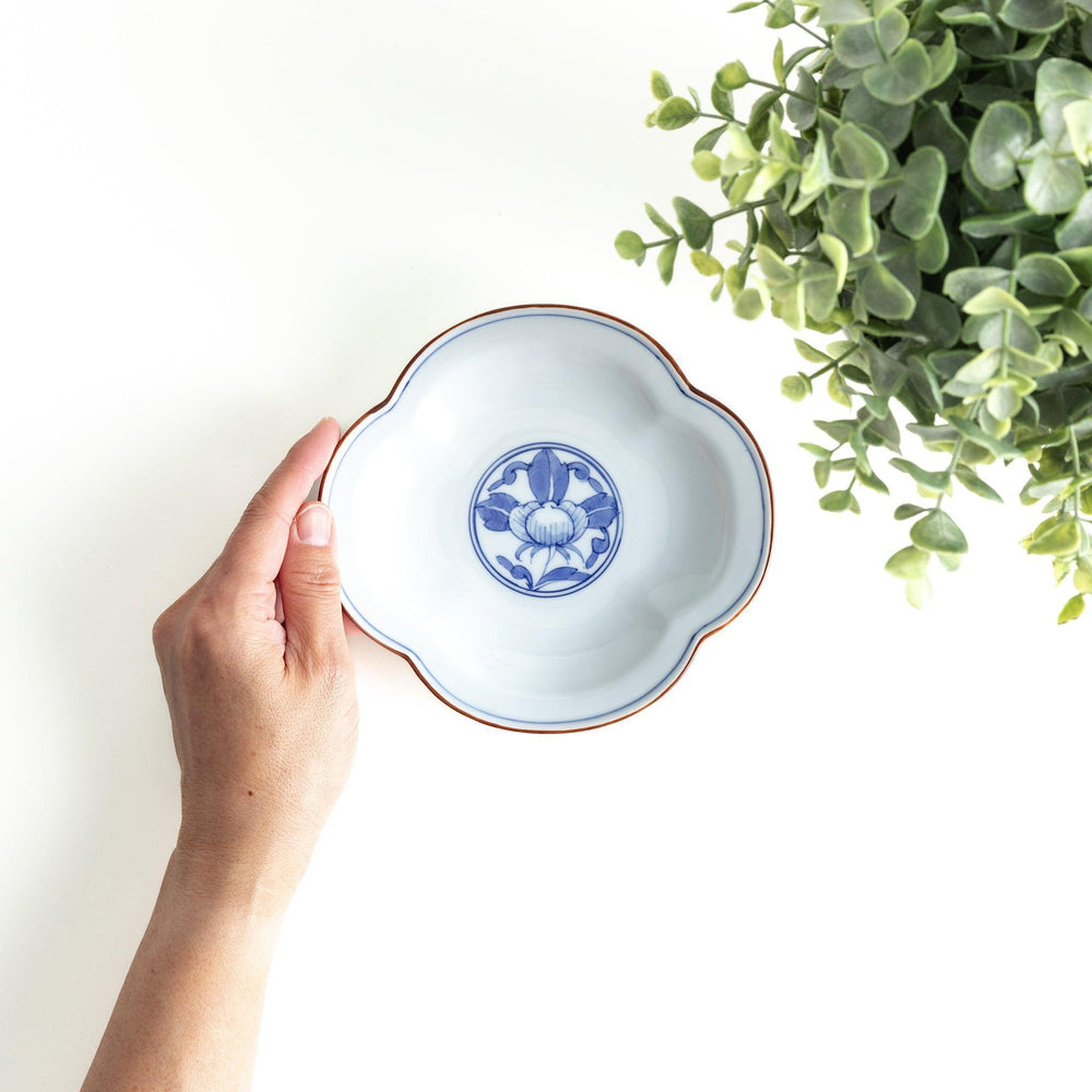 A blue and white porcelain dish with a floral motif in the center, shaped like a cloud.