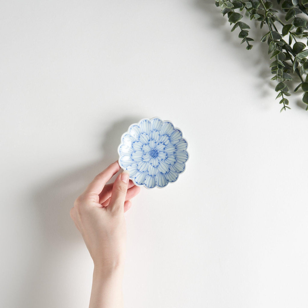 A small round dessert bowl with a delicate blue chrysanthemum pattern and scalloped edges.