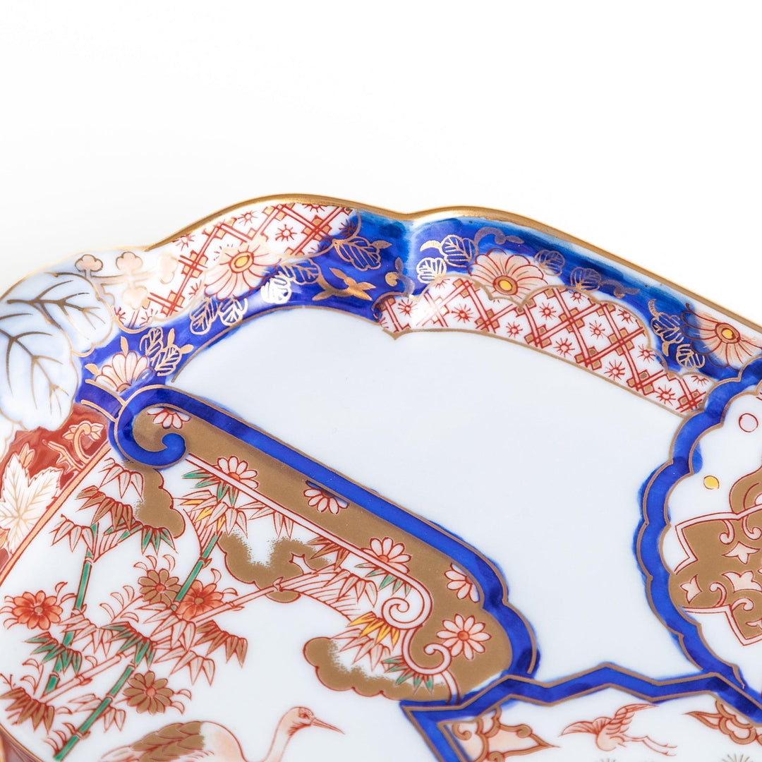 A rectangular salad plate with handles, decorated with scenes of cranes and trees in a traditional Japanese style, bordered by intricate red, blue, and gold patterns.