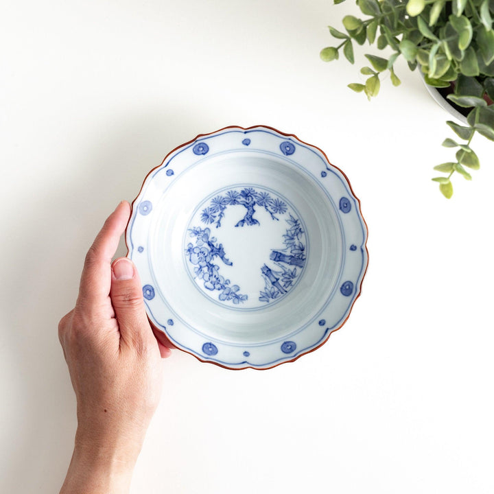 A white ceramic bowl with a blue floral design inside.