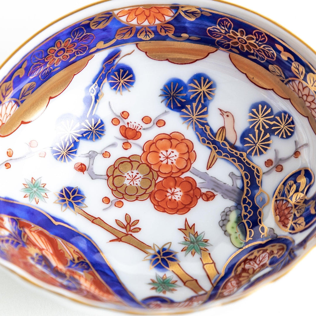 A small, triangular-shaped condiment bowl with intricate red, blue, and gold patterns featuring floral and geometric designs.