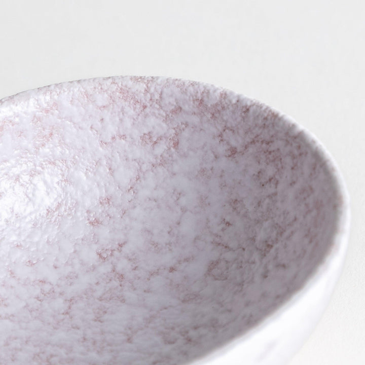 A condiment bowl with a soft pink speckled texture and a pouring spout.