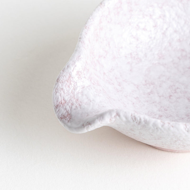 A condiment bowl with a soft pink speckled texture and a pouring spout.