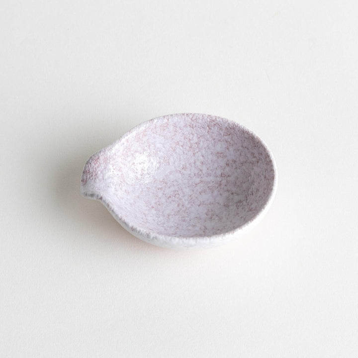 A condiment bowl with a soft pink speckled texture and a pouring spout.