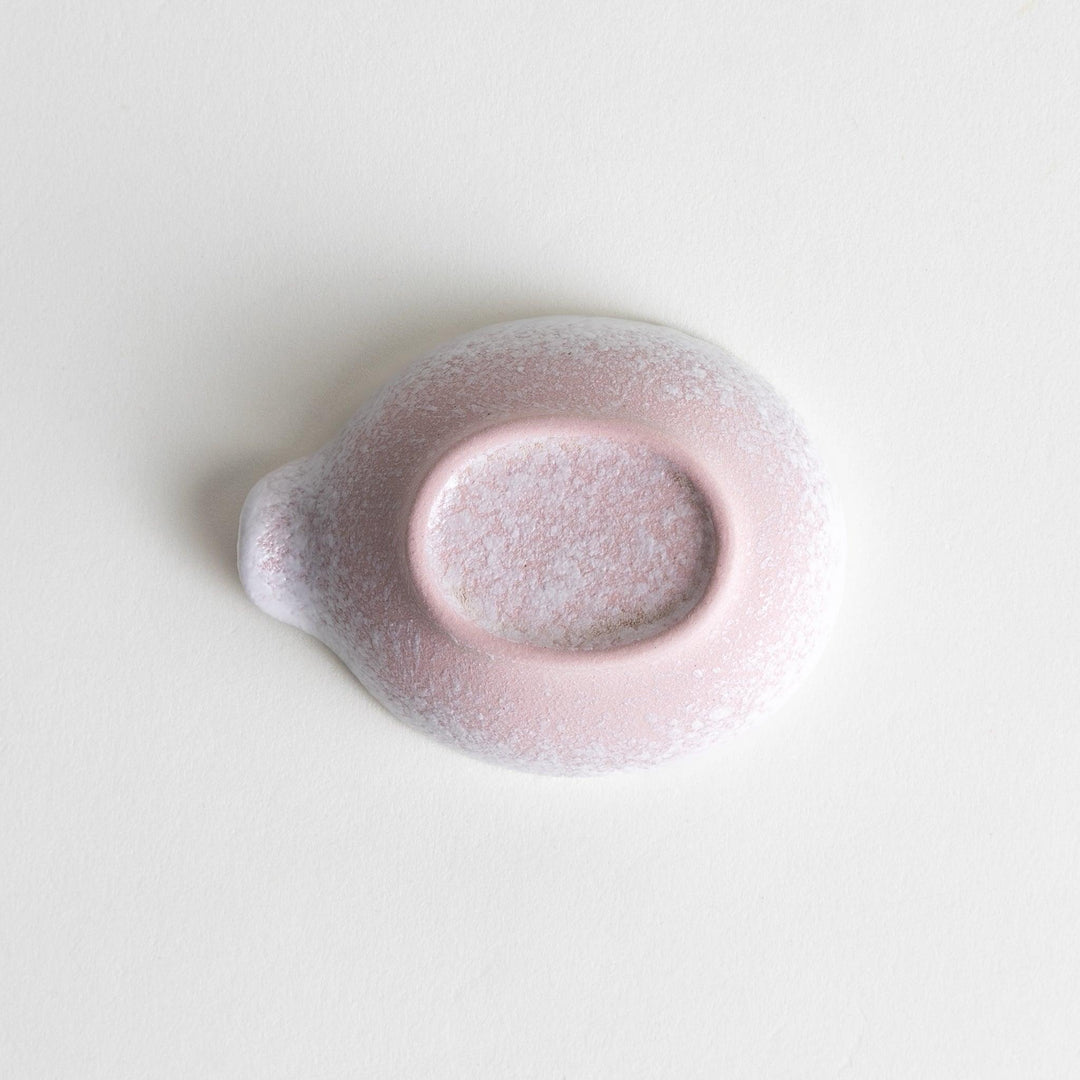 A condiment bowl with a soft pink speckled texture and a pouring spout.