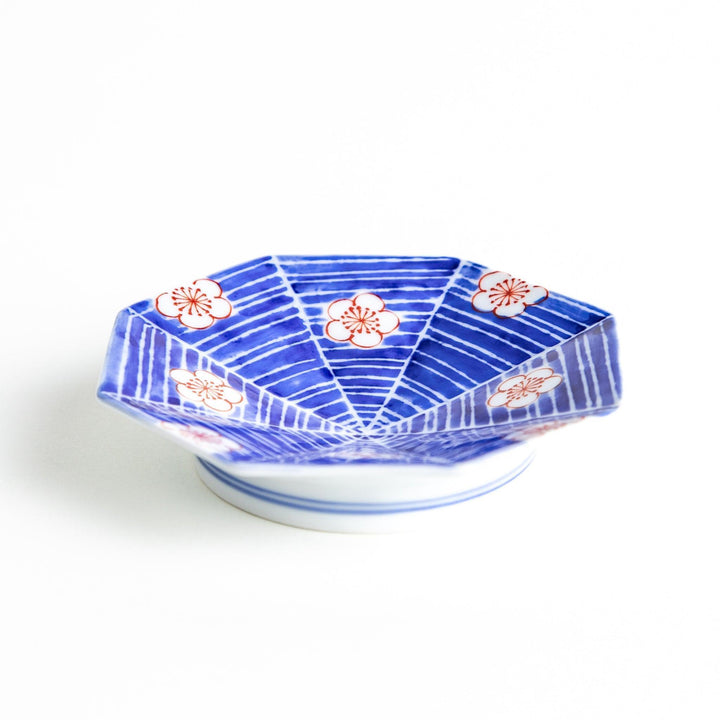 Octagonal blue plate with red and white flower patterns.