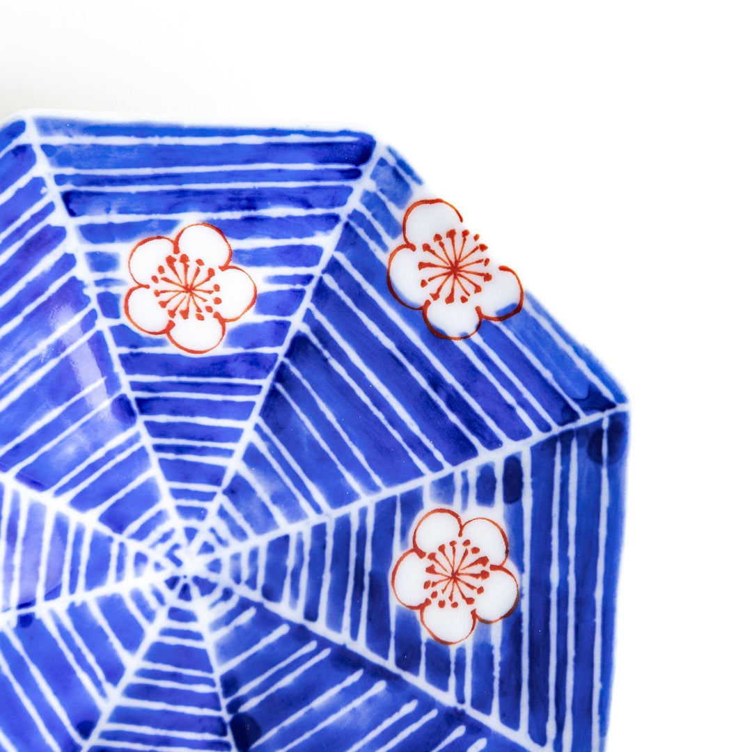 Octagonal blue plate with red and white flower patterns.