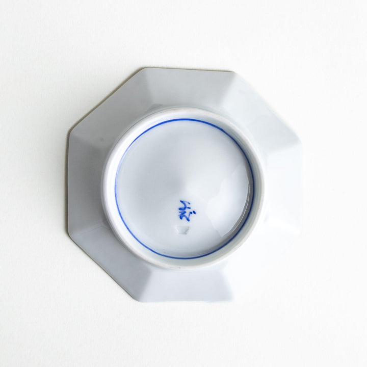 Octagonal blue plate with red and white flower patterns.