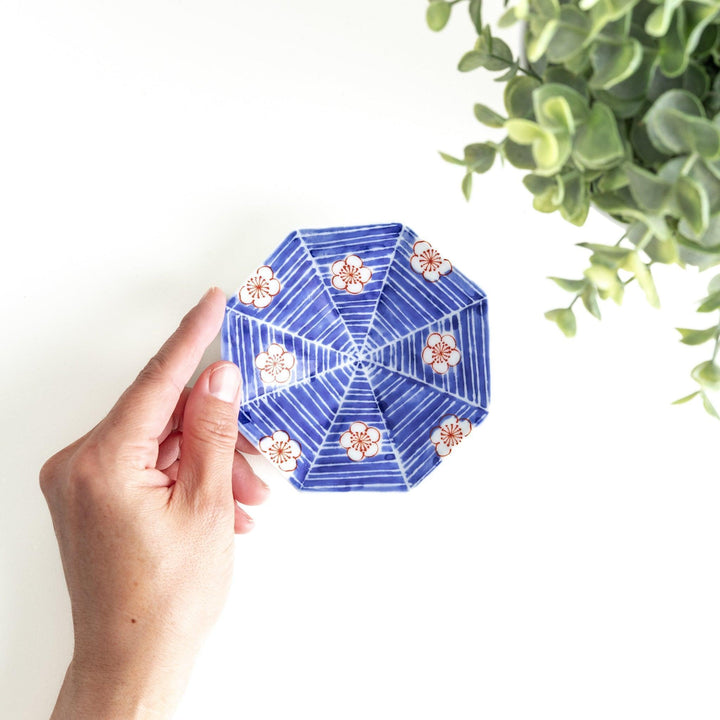 Octagonal blue plate with red and white flower patterns.