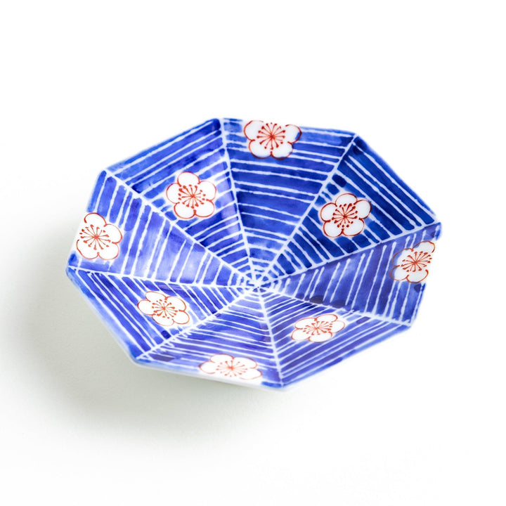 Octagonal blue plate with red and white flower patterns.