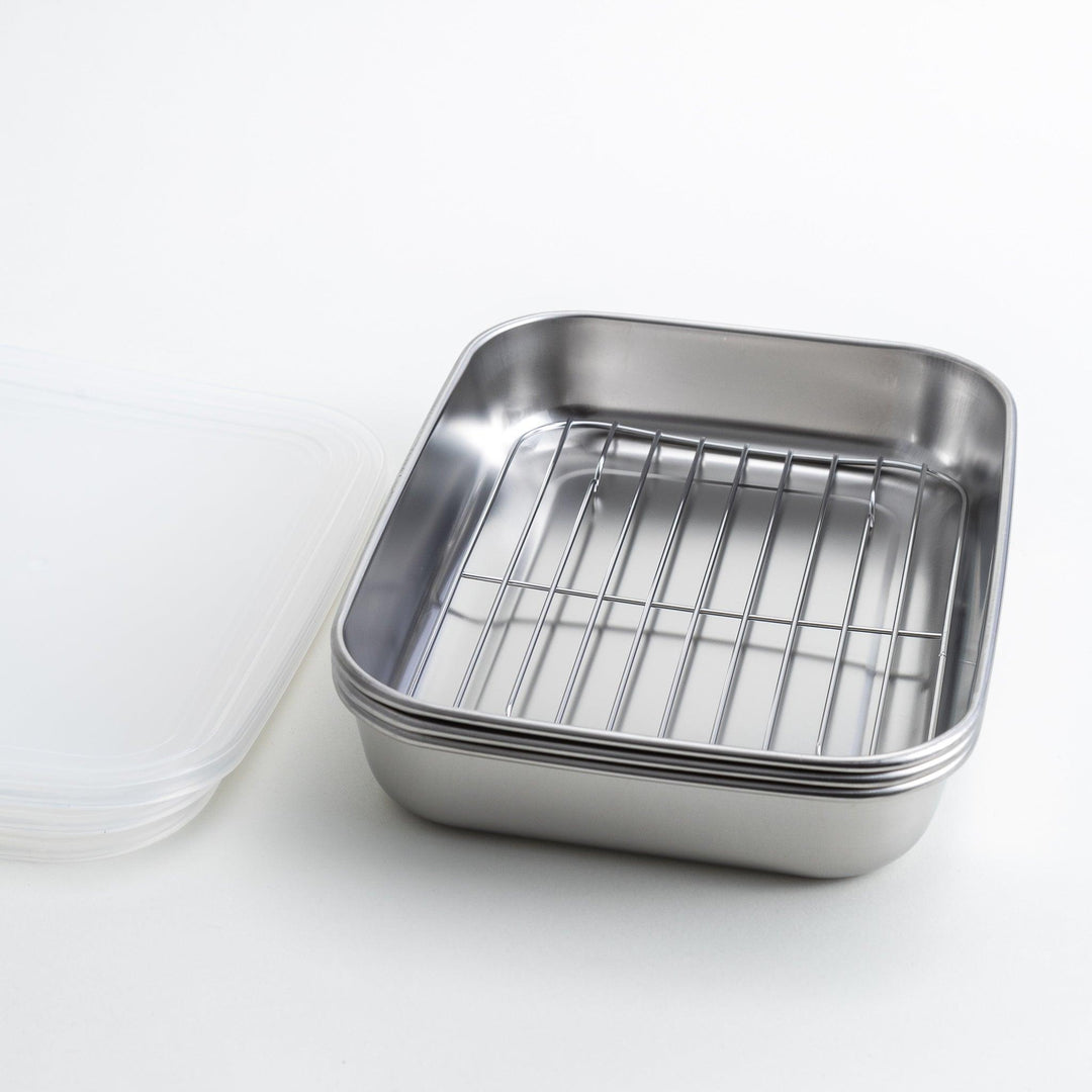 Rectangular stainless steel food prep trays with a wire rack and a white plastic lid.