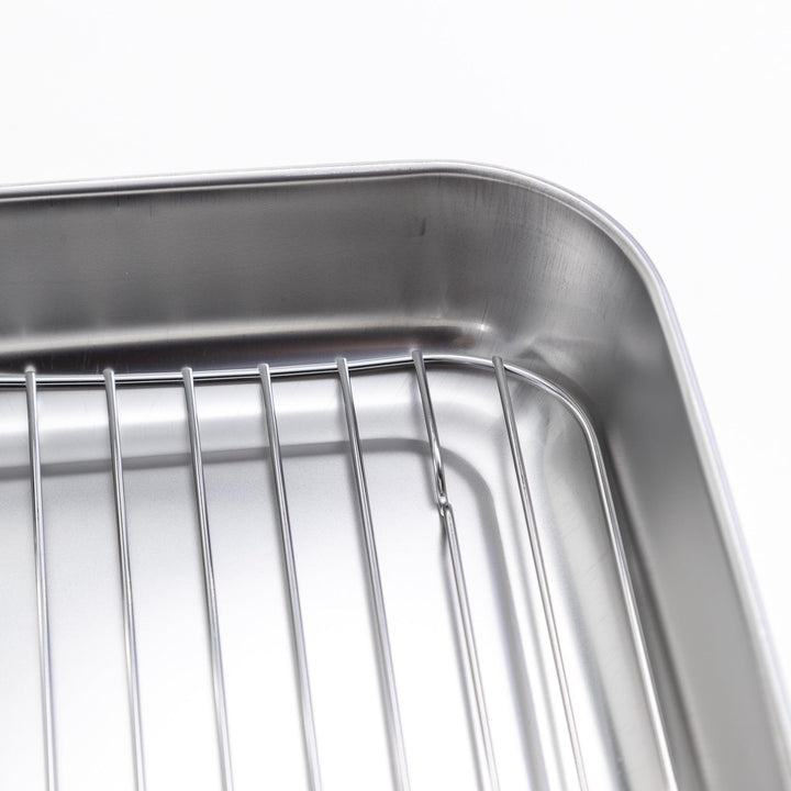 Rectangular stainless steel food prep trays with a wire rack and a white plastic lid.