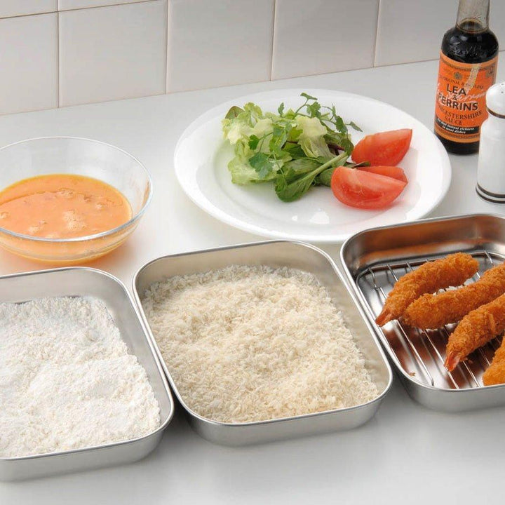 Rectangular stainless steel food prep trays with a wire rack and a white plastic lid.