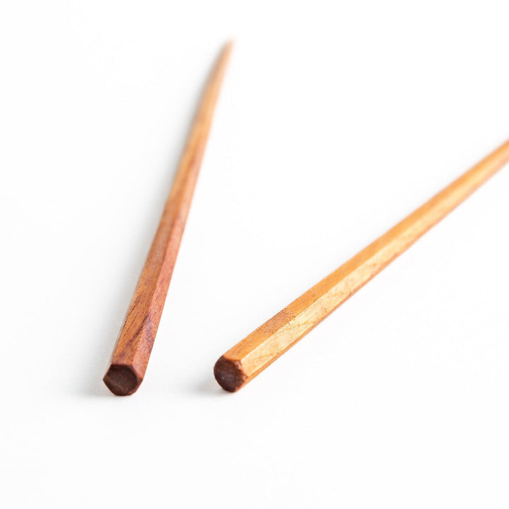 Three pairs of natural zelkova wood chopsticks, each with a different geometric shape—triangle, hexagon, and round.