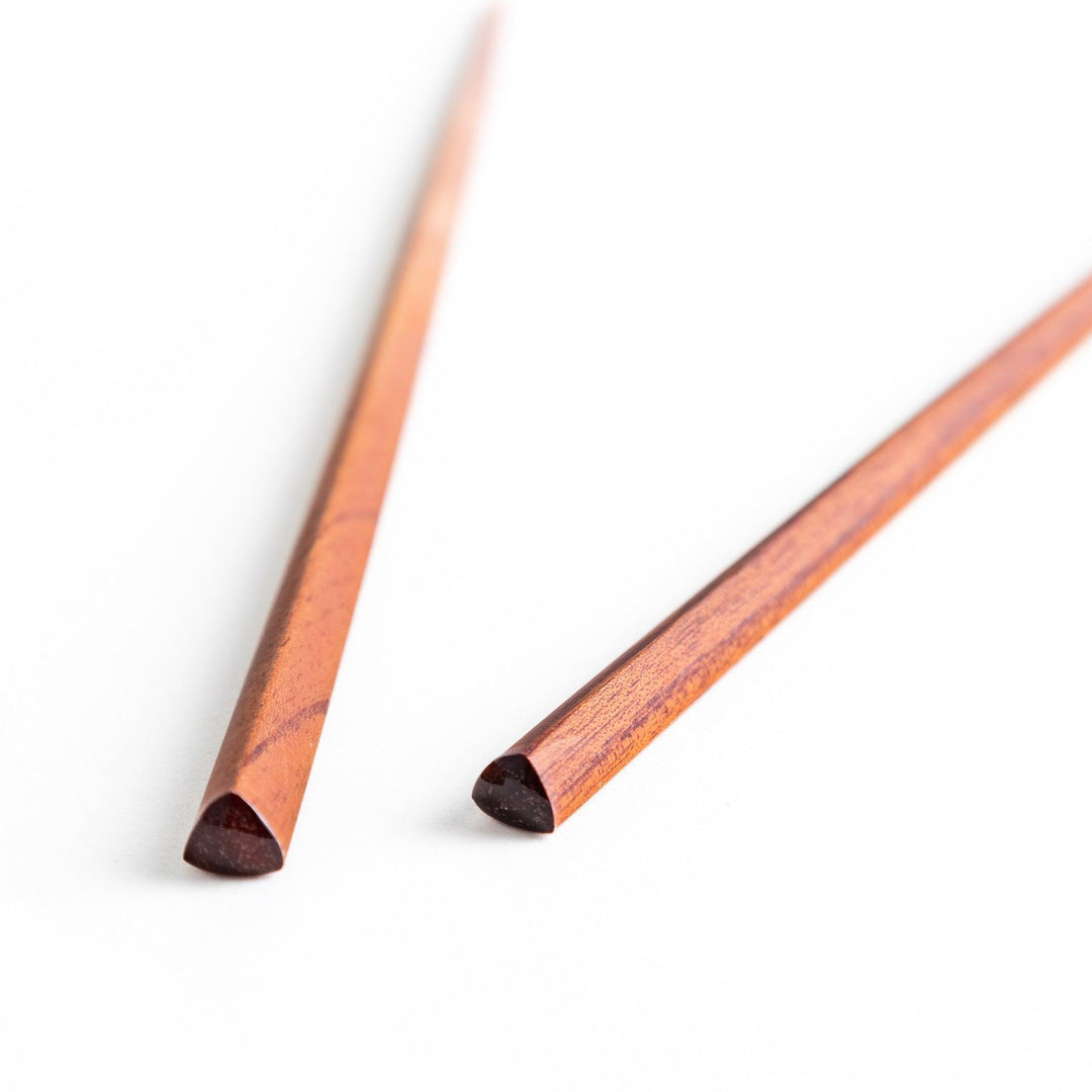 Three pairs of natural zelkova wood chopsticks, each with a different geometric shape—triangle, hexagon, and round.