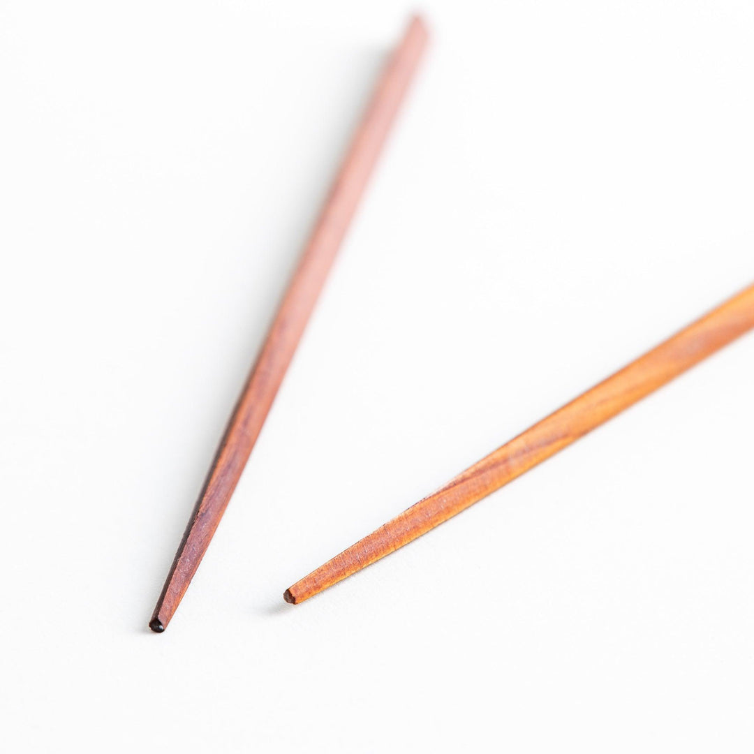 Three pairs of natural zelkova wood chopsticks, each with a different geometric shape—triangle, hexagon, and round.