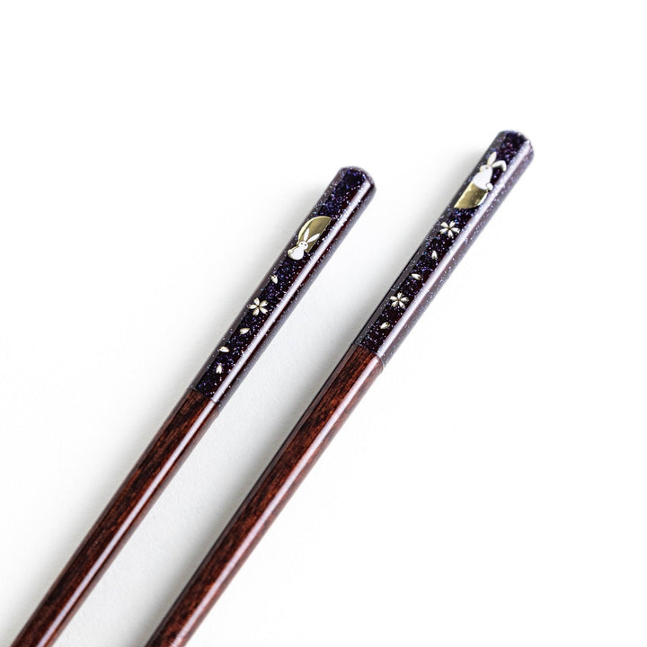 A pair of lacquered chopsticks adorned with floral patterns and rabbit. Available in purple or red.