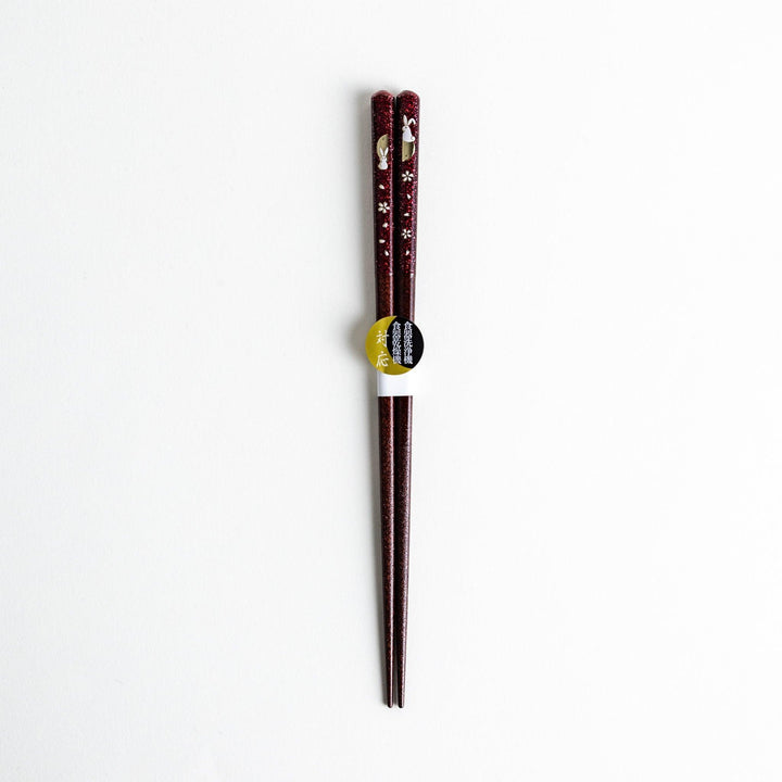 A pair of lacquered chopsticks adorned with floral patterns and rabbit. Available in purple or red.