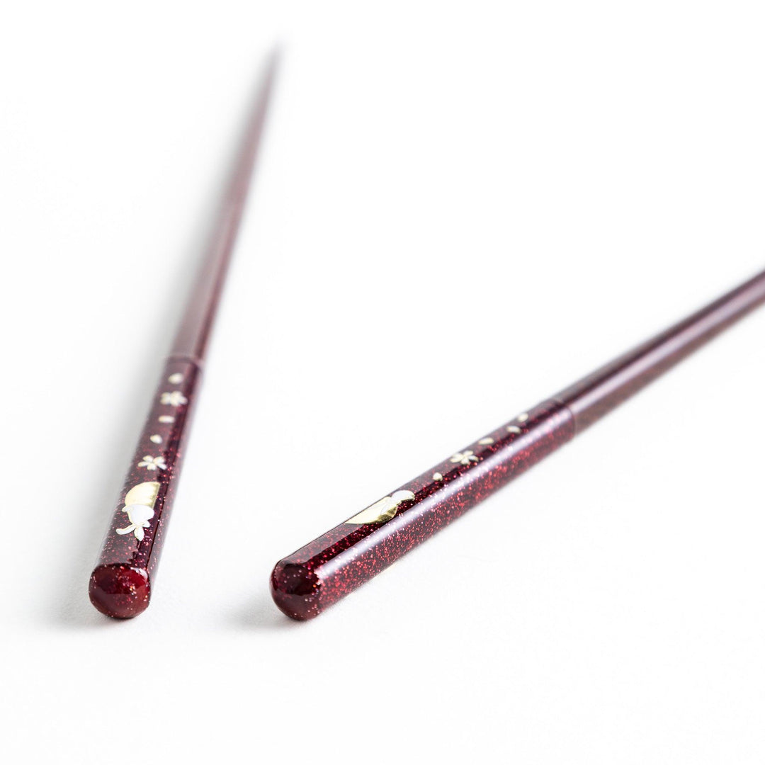 A pair of lacquered chopsticks adorned with floral patterns and rabbit. Available in purple or red.