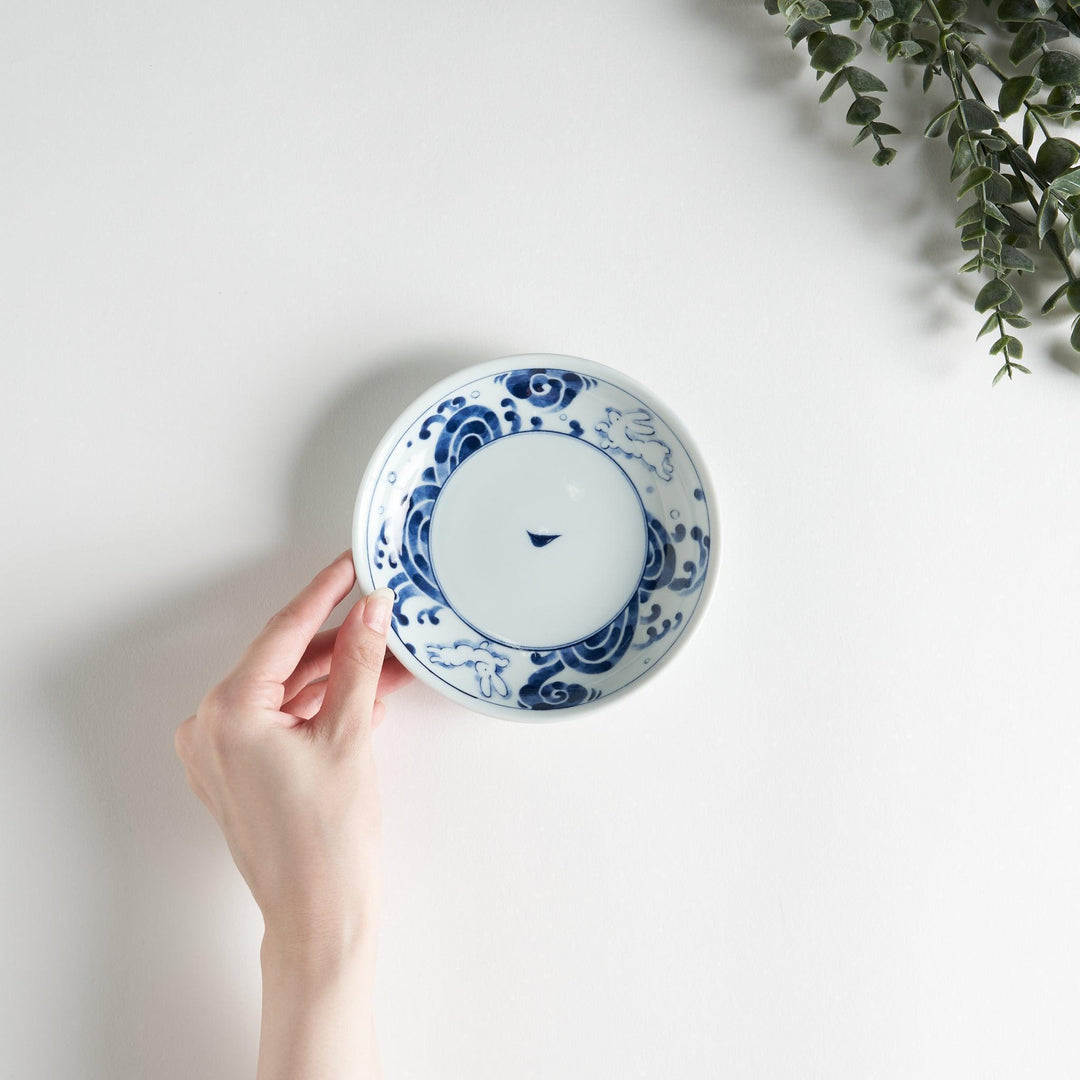 A dessert plate featuring blue waves and a rabbit motif on a white background.