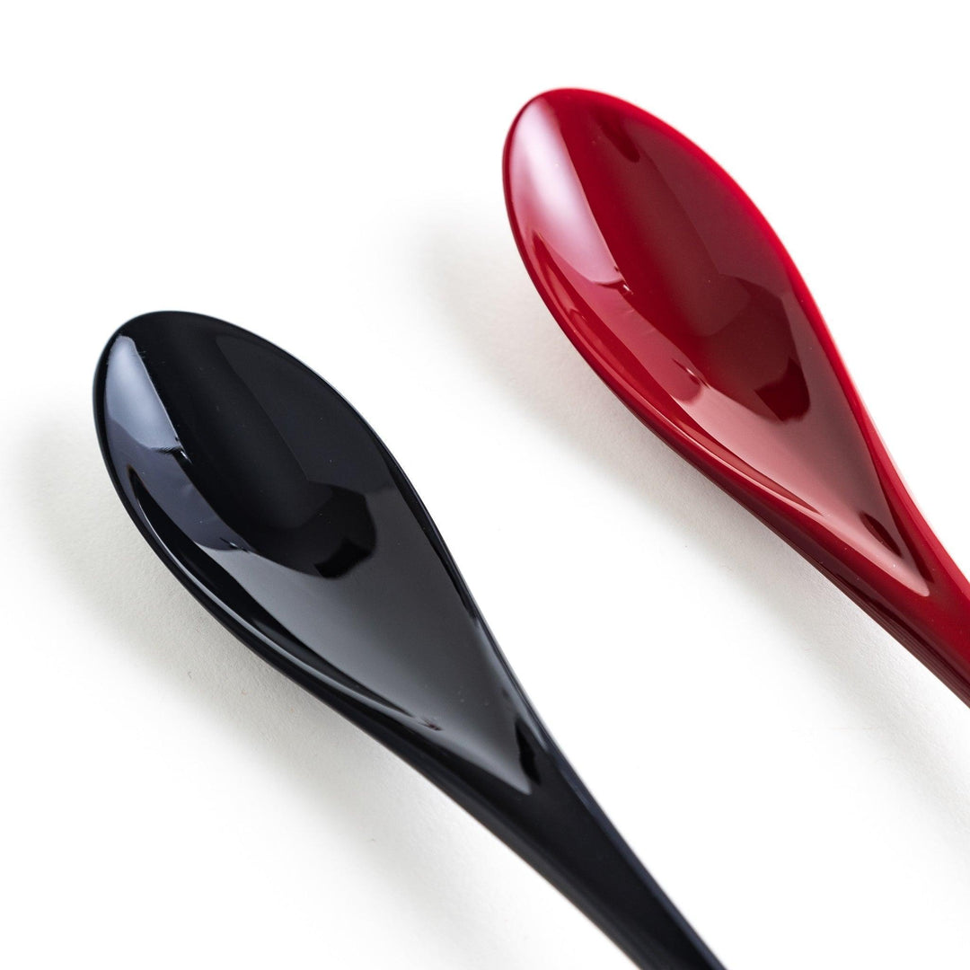 A boxed set of two lacquered spoons, one red and one black, each with gold sakura patterns on the handles.