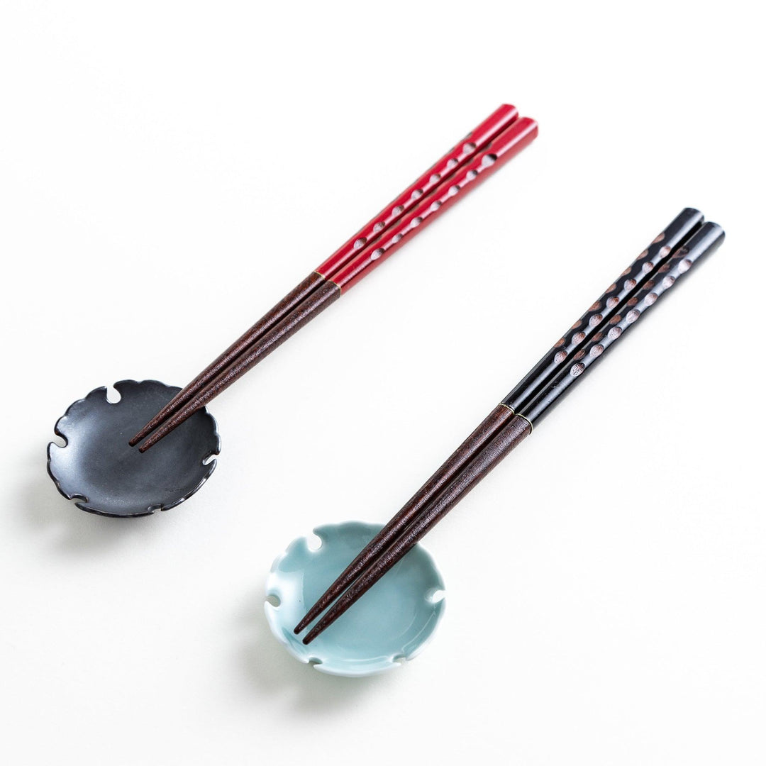 A boxed set of two pairs of chopsticks, one with black and one with red handles, both featuring textured grips.