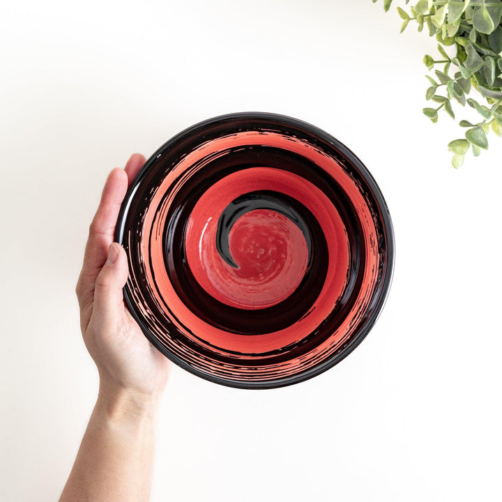 A black ramen bowl with a wide red brushstroke across its exterior.