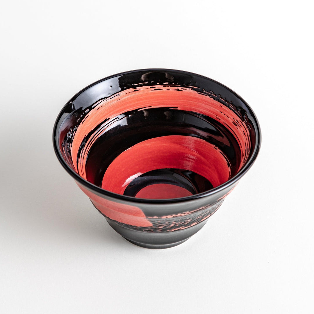 A black ramen bowl with a wide red brushstroke across its exterior.