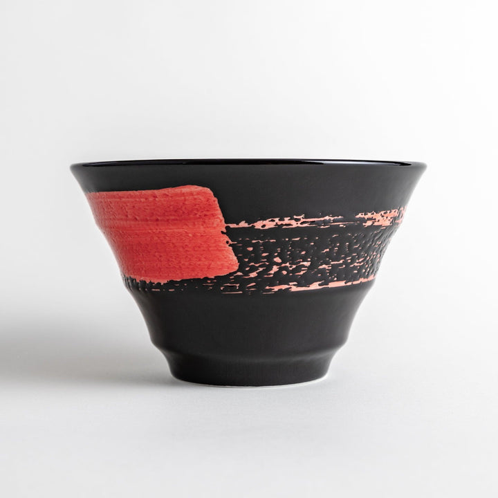 A black ramen bowl with a wide red brushstroke across its exterior.